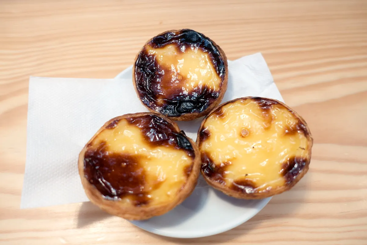 Three pastéis de nata with blistered tops
