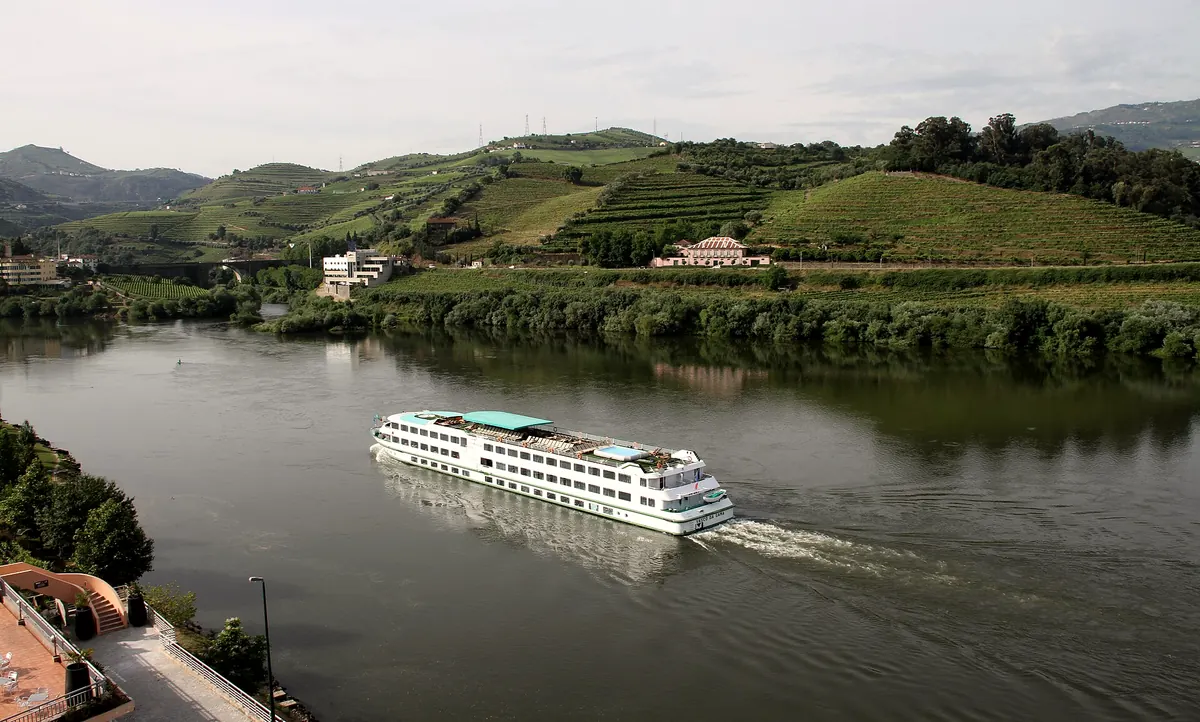 A river cruise ship passing vineyards near Peso da Régua